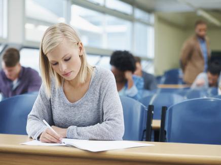Young woman taking a scantron test at a table. 