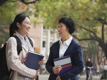 teacher and student talk outside on campus