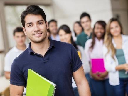 Latino male standing in front of a crowd of students