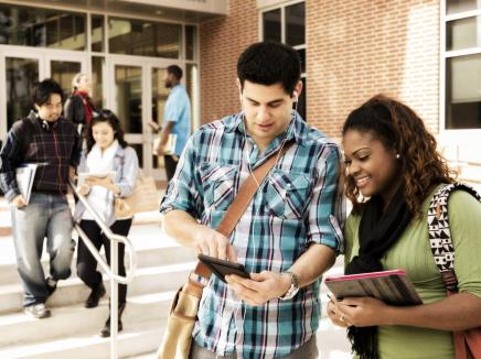 Diverse group of college students talk, study before class. 