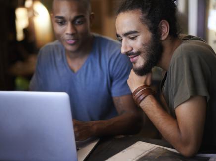 two young men on a laptop