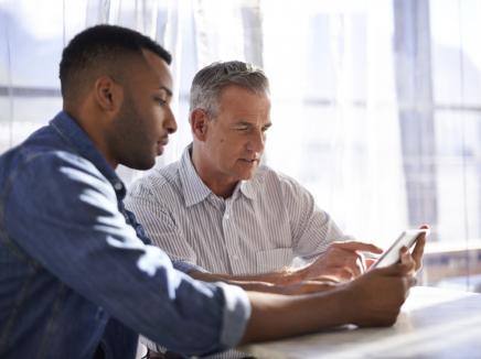 Two men working together at a table. 