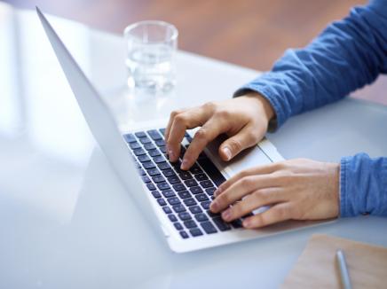 birds eye view of man typing on laptop 