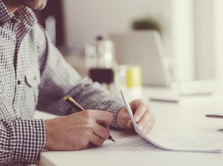 Man signing a document.