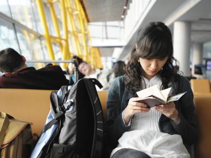 Person reading next to backpack