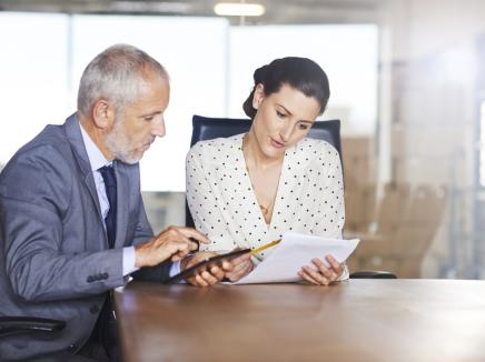 Two individuals studying documents