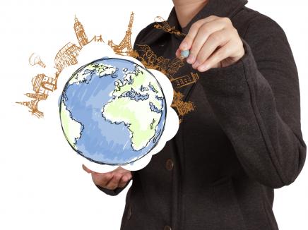 Girl pointing at globe to prepare for summer travel.