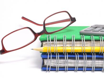 Glasses, notebooks, pencil and calculator.